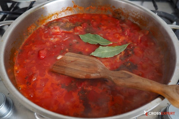 Добавьте томаты в собственном соку, специи, сахар и соль