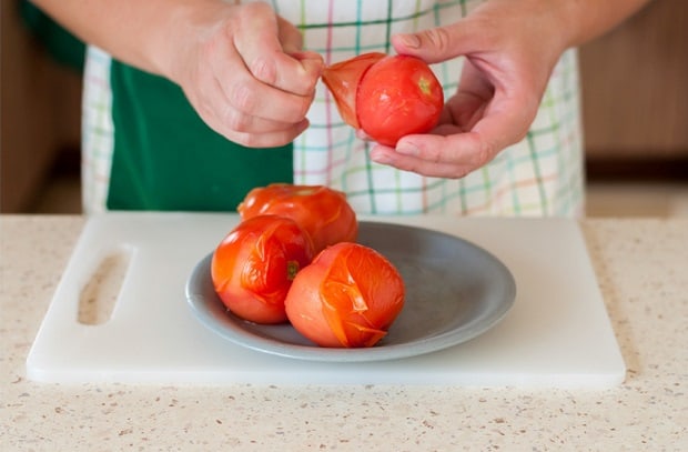 бланшированные помидоры на тарелке на столе