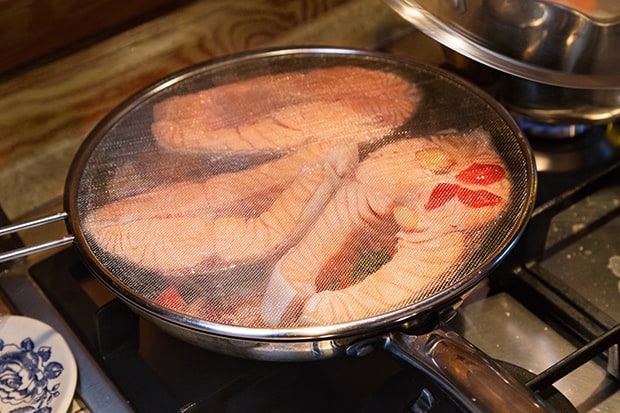 стейки лосося под крышкой на сковороде на плите