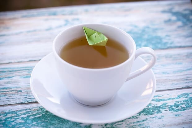 зеленый чай в белой чашке на столе