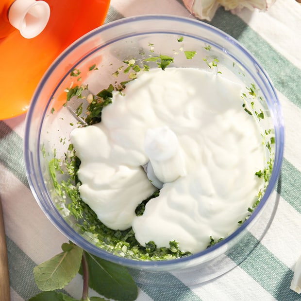 йогурт с измельченной зеленью в чаше блендера