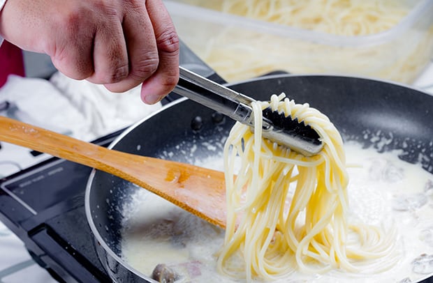 спагетти добавляются в сковороду со сливками